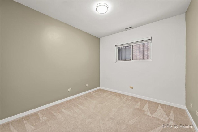 empty room featuring light carpet, visible vents, and baseboards