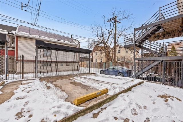 snowy yard featuring fence