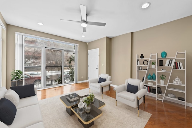 living area featuring baseboards, dark wood-type flooring, a ceiling fan, and recessed lighting