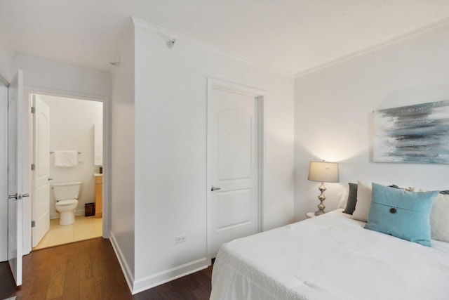 bedroom featuring ensuite bathroom, ornamental molding, dark wood finished floors, and baseboards