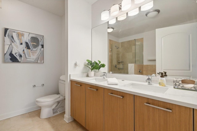 bathroom featuring toilet, a stall shower, double vanity, and a sink