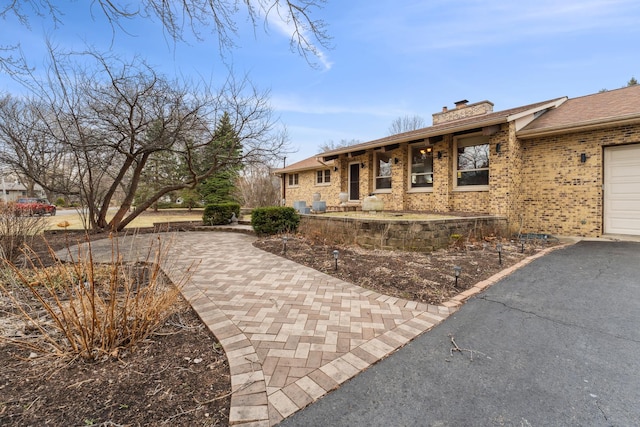 26980 N Pierre Dr, Mundelein, IL 60060 - ranch-style house featuring a chimney, brick siding, and asphalt driveway