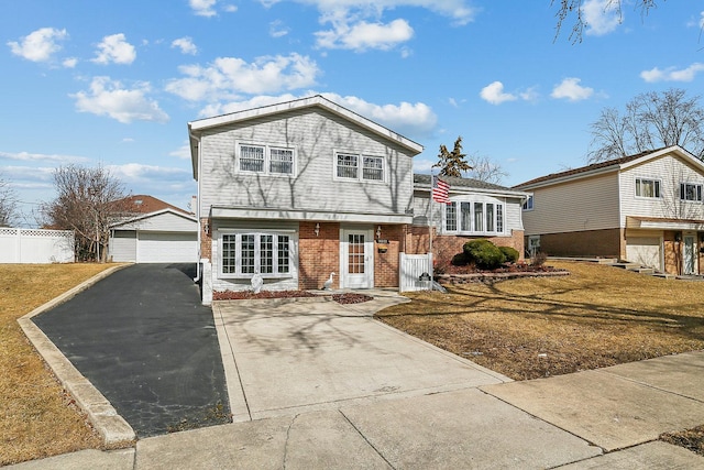 view of front of house with a garage, brick siding, an outdoor structure, fence, and a front lawn