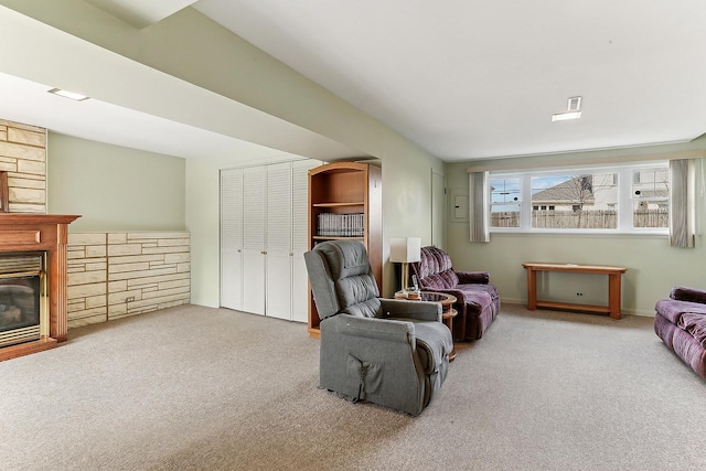 carpeted living room with a glass covered fireplace