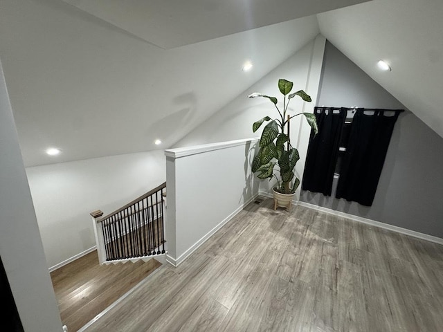 additional living space featuring lofted ceiling, recessed lighting, wood finished floors, and baseboards