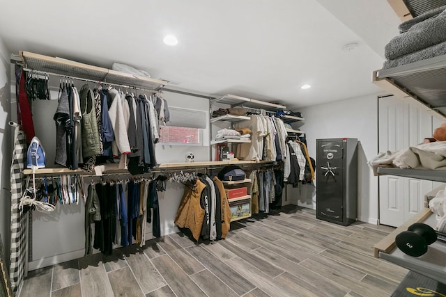 walk in closet with wood finish floors