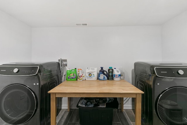 washroom featuring washer and dryer, laundry area, visible vents, and dark wood-style flooring