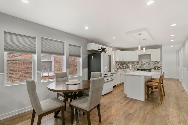 dining room featuring light wood-style floors, baseboards, and recessed lighting