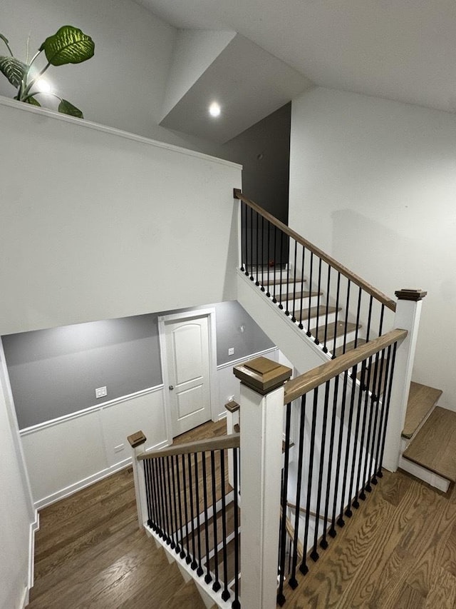 stairs featuring vaulted ceiling and wood finished floors