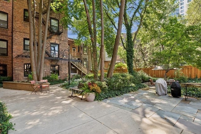 view of property's community featuring stairs, a patio, and fence