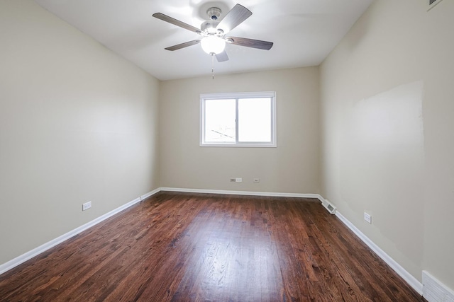 empty room with a ceiling fan, dark wood-style flooring, visible vents, and baseboards