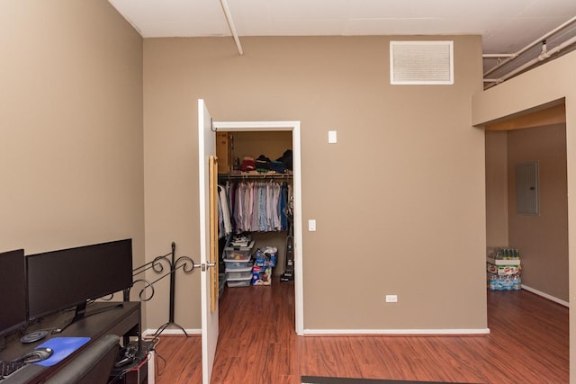 bedroom featuring baseboards, visible vents, wood finished floors, a spacious closet, and a closet