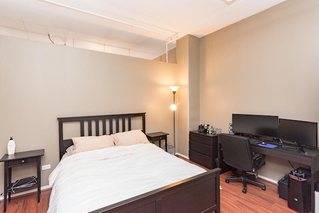 bedroom with baseboards and wood finished floors