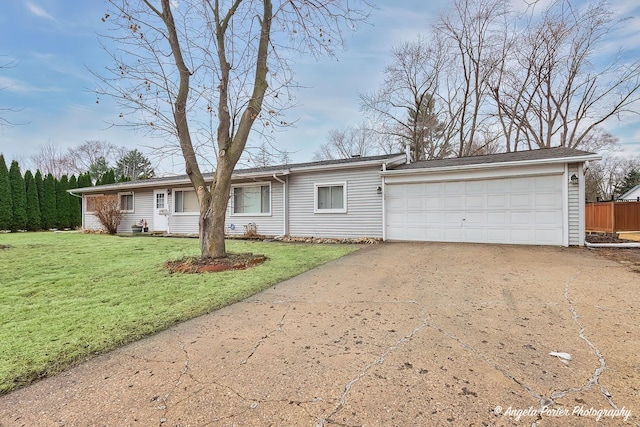 ranch-style house featuring a garage, a front lawn, and driveway