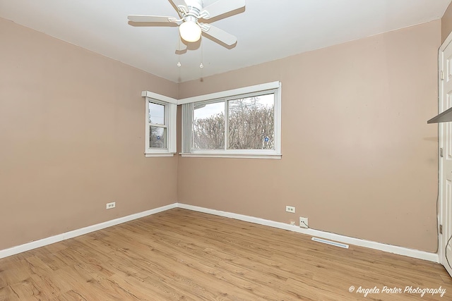 empty room with visible vents, ceiling fan, light wood-style flooring, and baseboards