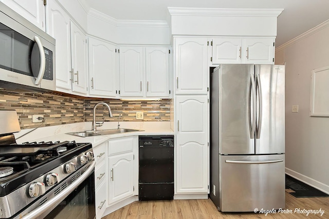 kitchen featuring tasteful backsplash, white cabinets, appliances with stainless steel finishes, ornamental molding, and a sink