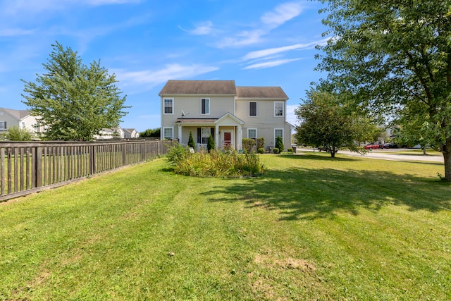 view of front of house with fence and a front lawn