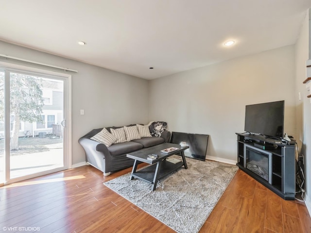 living room with baseboards, wood finished floors, and recessed lighting