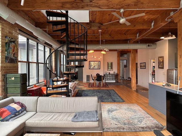 living area with visible vents, a ceiling fan, stairway, beamed ceiling, and wood finished floors