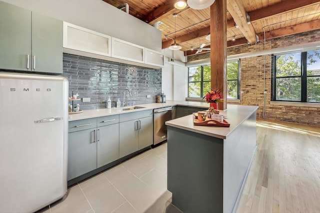 kitchen with backsplash, stainless steel dishwasher, freestanding refrigerator, wood ceiling, and a sink