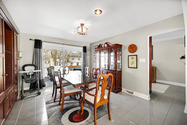 dining room featuring light tile patterned floors and baseboards