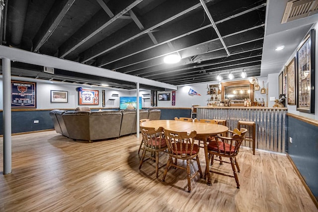 dining room featuring visible vents, a bar, and wood finished floors