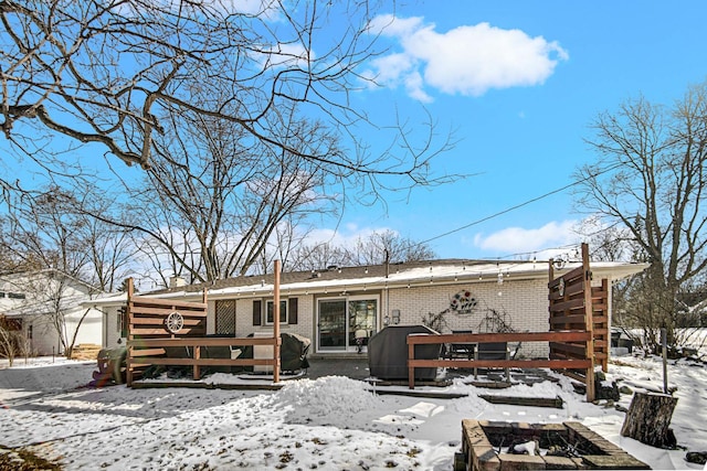 snow covered house featuring brick siding