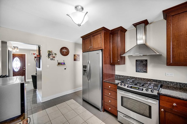 kitchen featuring stainless steel appliances, baseboards, dark stone countertops, and wall chimney exhaust hood