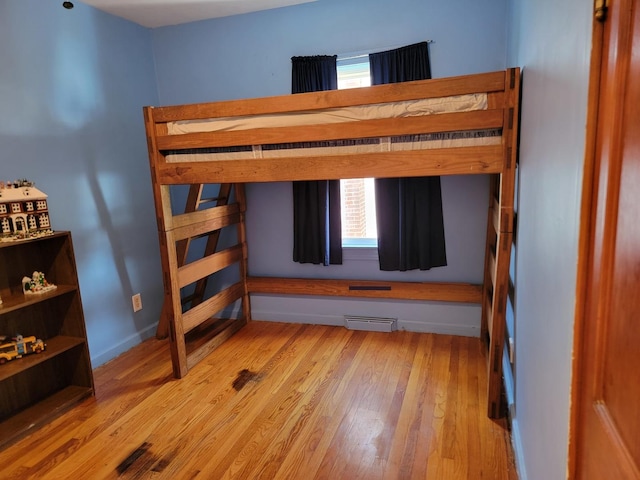 bedroom featuring light wood finished floors, visible vents, and baseboards