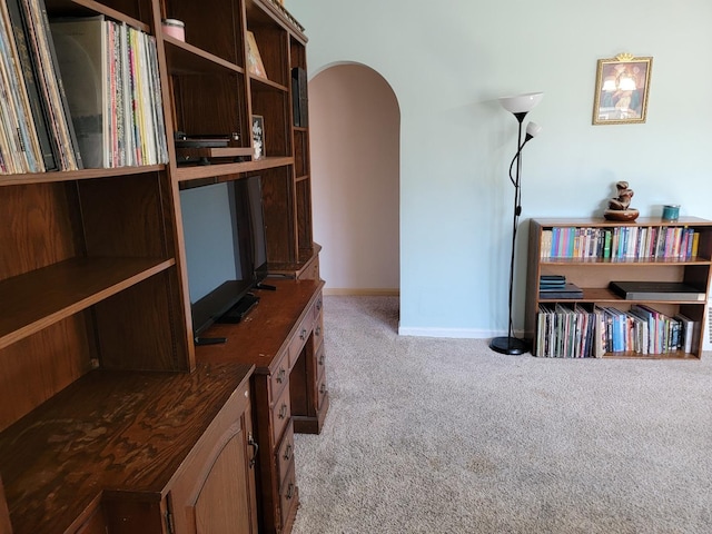 interior space featuring baseboards and arched walkways