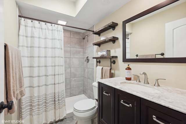 bathroom featuring toilet, tiled shower, and vanity