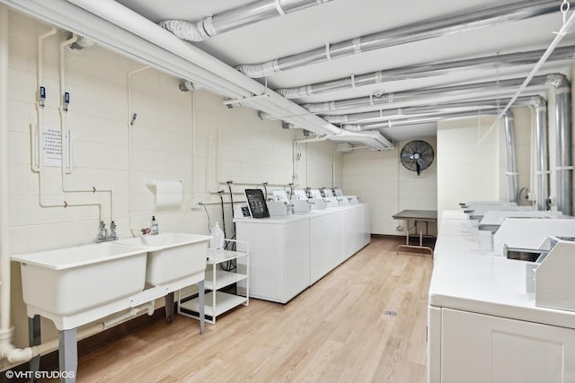 community laundry room with light wood-type flooring and washing machine and dryer