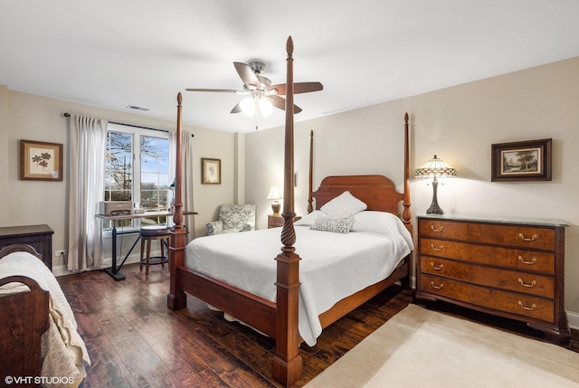 bedroom featuring baseboards, ceiling fan, visible vents, and wood finished floors