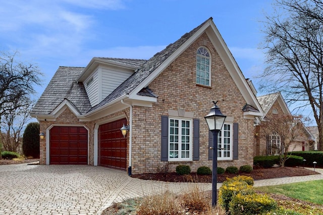 view of side of home with brick siding and decorative driveway