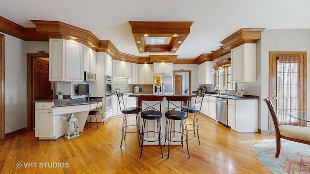 kitchen with light wood-style flooring, white cabinetry, stainless steel appliances, and a sink