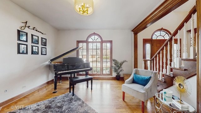 living area featuring baseboards, stairway, and wood finished floors