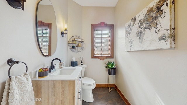 bathroom featuring tile patterned flooring, baseboards, vanity, and toilet