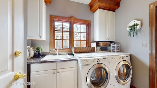 laundry area with separate washer and dryer, a sink, and cabinet space