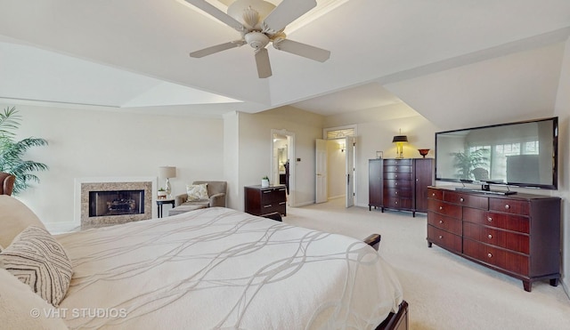 bedroom with light colored carpet, a fireplace, baseboards, and ceiling fan