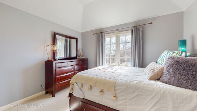 bedroom featuring baseboards, vaulted ceiling, and light colored carpet