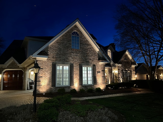 view of front of home featuring brick siding, driveway, and an attached garage