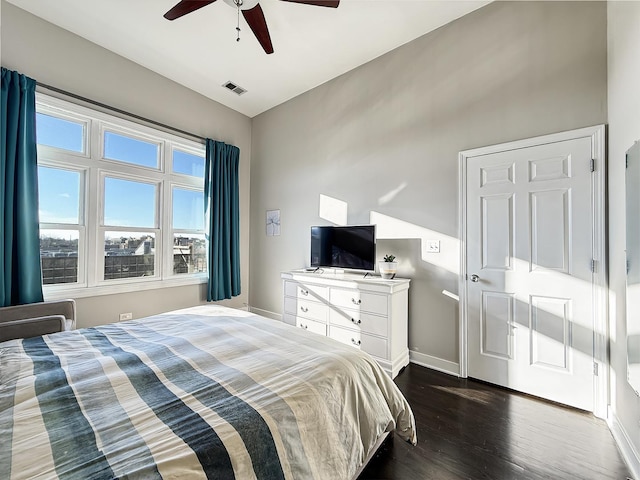 bedroom with lofted ceiling, visible vents, dark wood-type flooring, a ceiling fan, and baseboards