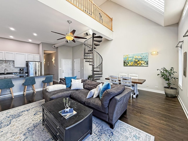 living room featuring baseboards, a ceiling fan, dark wood-type flooring, stairs, and recessed lighting