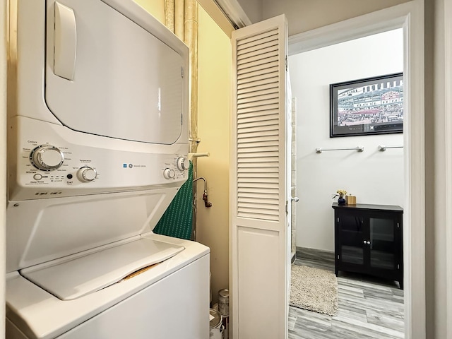 washroom featuring laundry area, light wood finished floors, and stacked washing maching and dryer