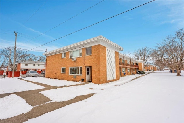 view of snow covered exterior featuring brick siding