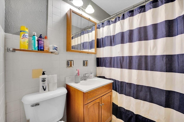 full bathroom featuring toilet, a shower with shower curtain, vanity, tile walls, and tasteful backsplash