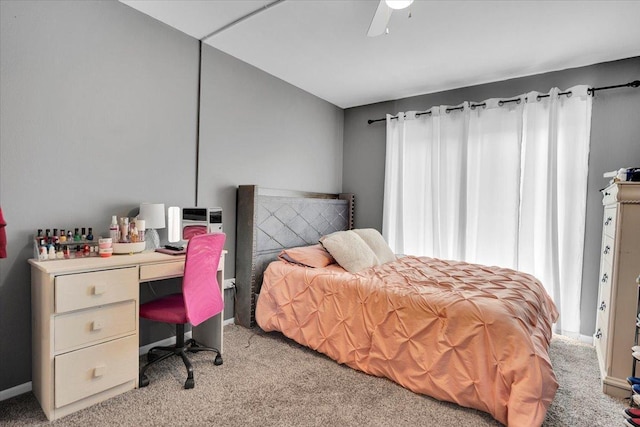 bedroom featuring a ceiling fan, light carpet, baseboards, and multiple windows