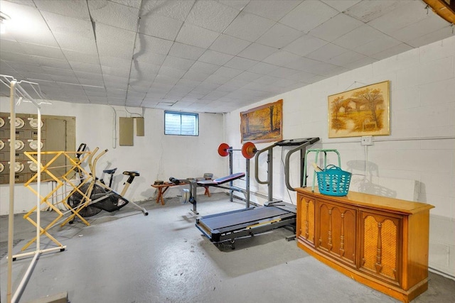 exercise room featuring concrete block wall