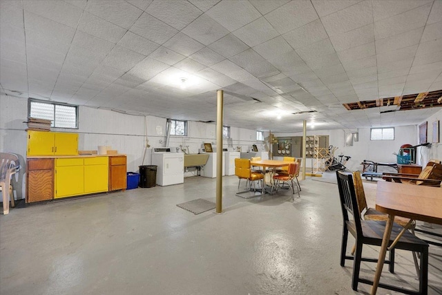 basement with a sink, a wealth of natural light, and independent washer and dryer