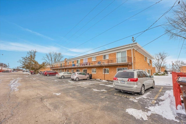 exterior space featuring uncovered parking and brick siding